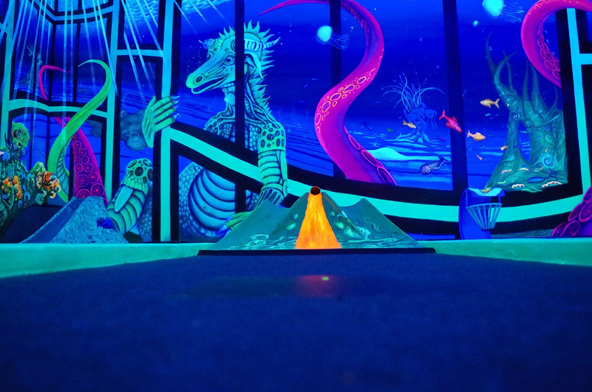 3D black light mini golf in Berlin – glowing underwater scene at Dockx