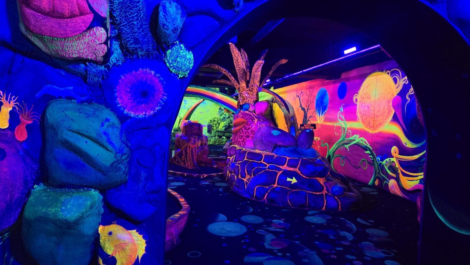3D Schwarzlicht-Minigolf Berlin – kunstvoll gestaltete leuchtende Bahn unter UV-Licht im Dockx am Tempelhofer Hafen